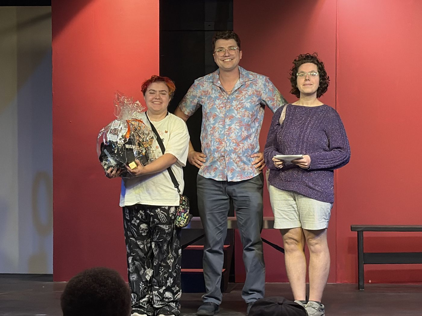 The first-place team on stage with the organizer, holding their prize basket