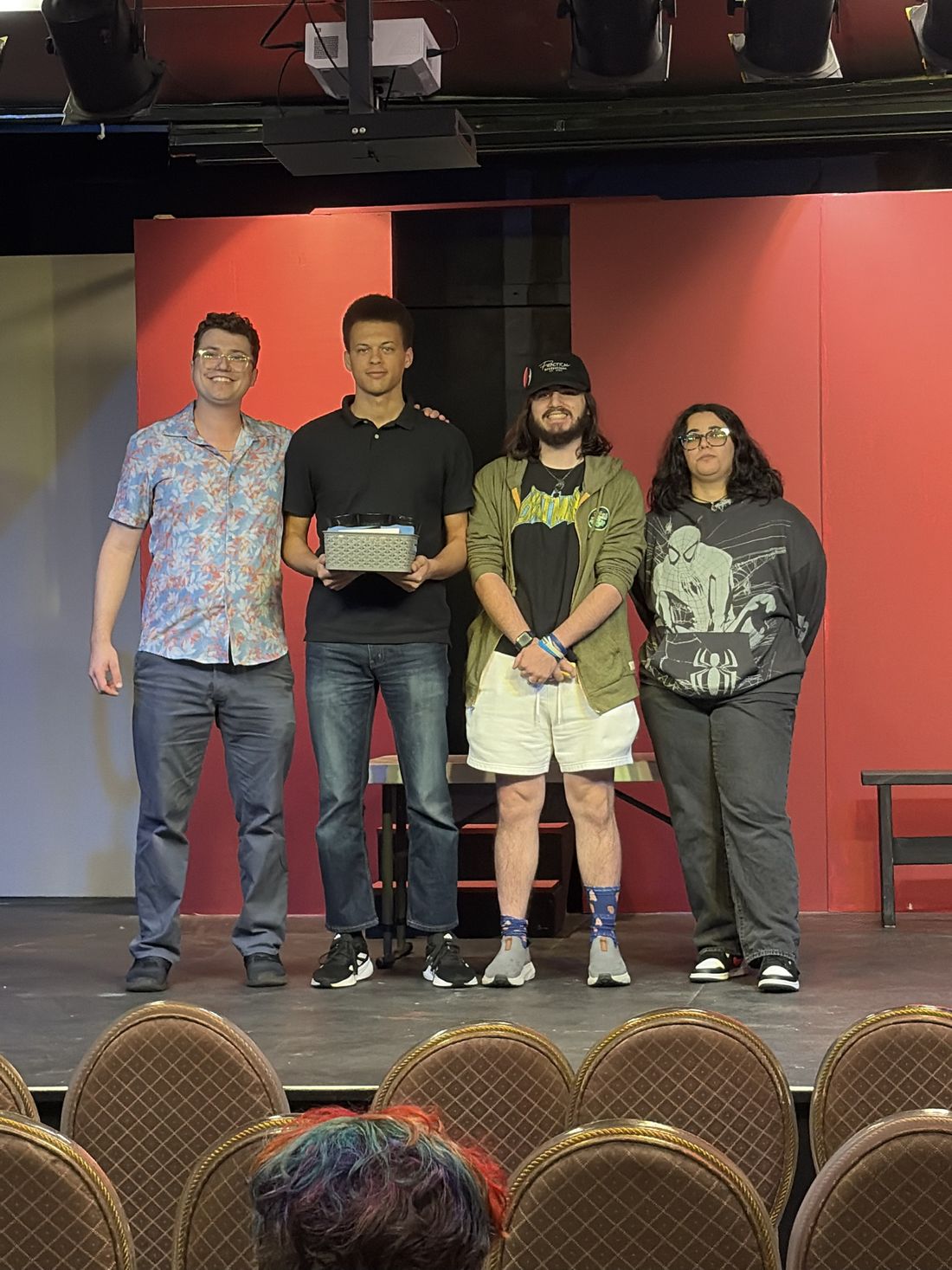 The second-place team on stage with the organizer, holding their prize basket