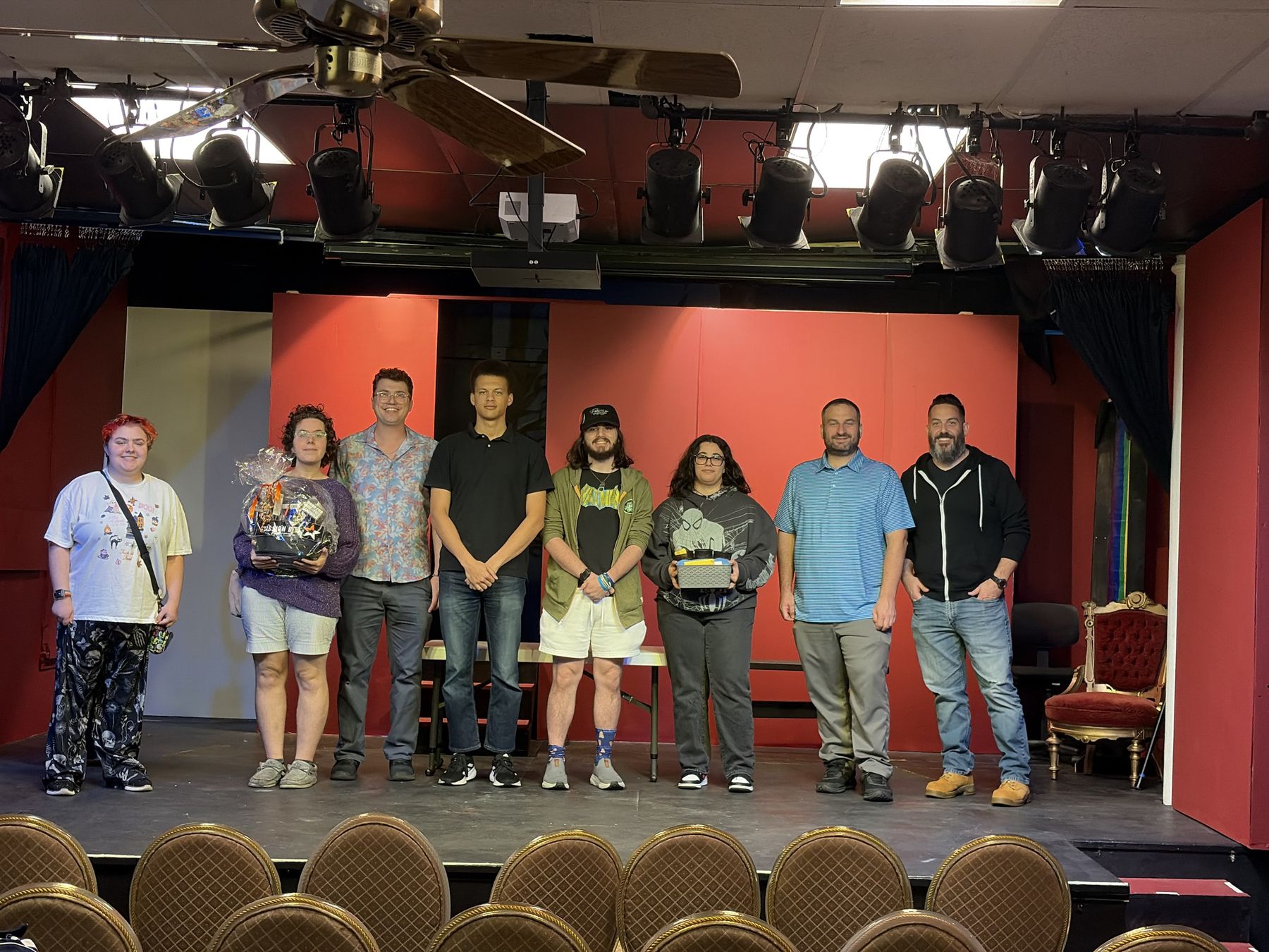 Group photo on the Blue Moon Theatre stage: both winning teams, the organizer and the judges